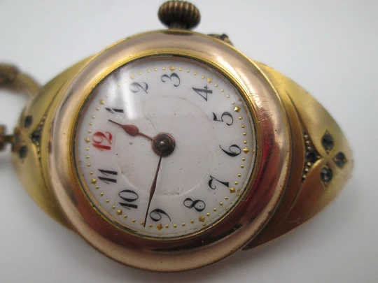 Art deco ladie's wrist watch. Gold plated. Porcelain sphere and white gems. 1920's