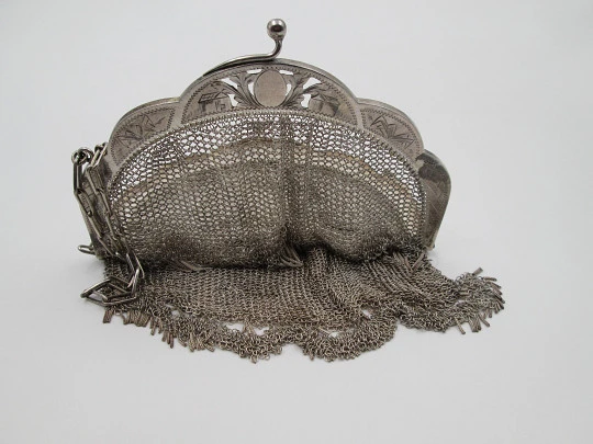 Bolso de malla con cadena. Boquilla cincelada y remate flecos. Plata de ley. Europa. 1920