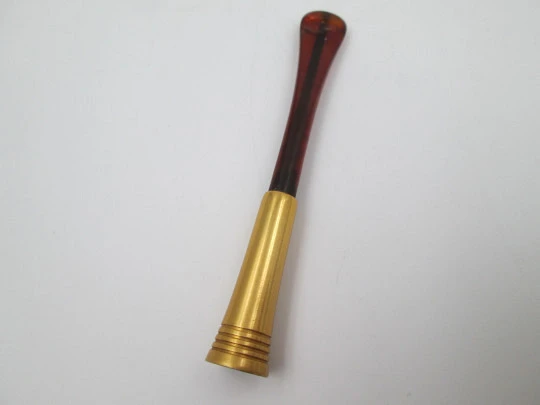 Boquilla para cigarrillos con muelle. Metal dorado y celuloide ámbar. Europa. 1940