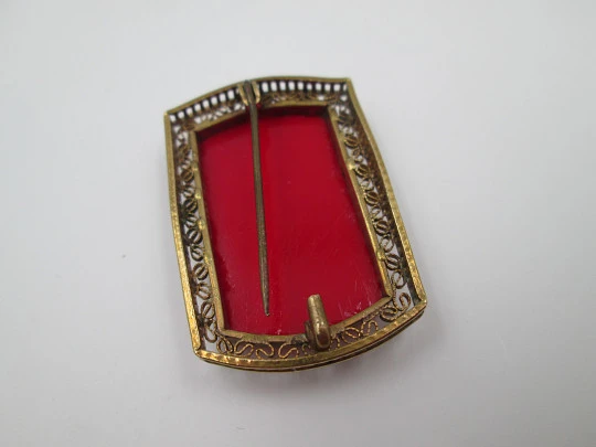 Broche para mujer. Metal dorado y resina roja. Grabados florales y cerco calado. 1960