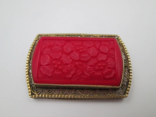 Broche para mujer. Metal dorado y resina roja. Grabados florales y cerco calado. 1960