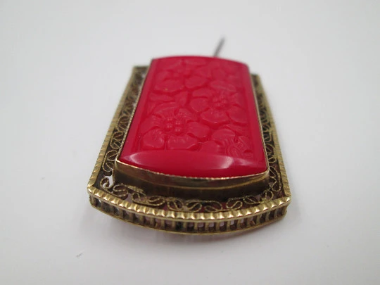 Broche para mujer. Metal dorado y resina roja. Grabados florales y cerco calado. 1960