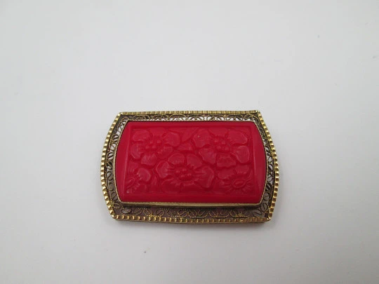 Broche para mujer. Metal dorado y resina roja. Grabados florales y cerco calado. 1960