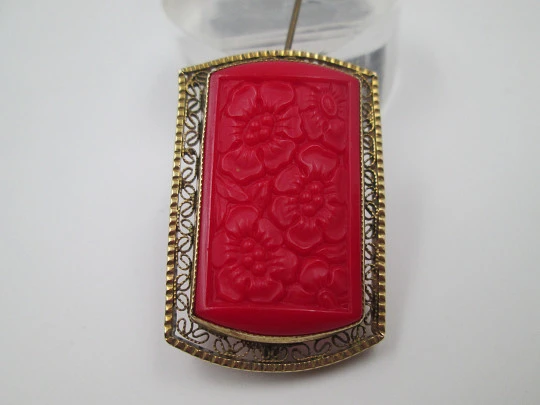 Broche para mujer. Metal dorado y resina roja. Grabados florales y cerco calado. 1960