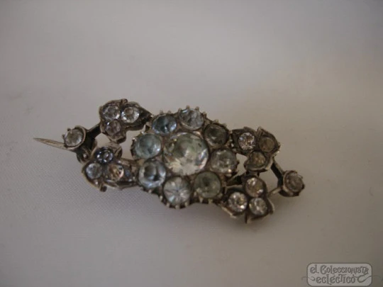 Broche. Plata y piedras blancas. Años 20. Montura hojas y flor