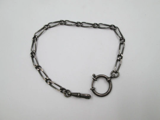 Cadena para reloj bolsillo. Metal pavonado. Eslabones abiertos. Mosquetón y argolla. 1940