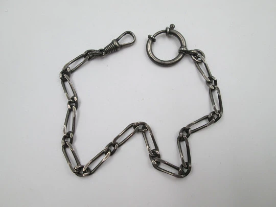 Cadena para reloj bolsillo. Metal pavonado. Eslabones abiertos. Mosquetón y argolla. 1940