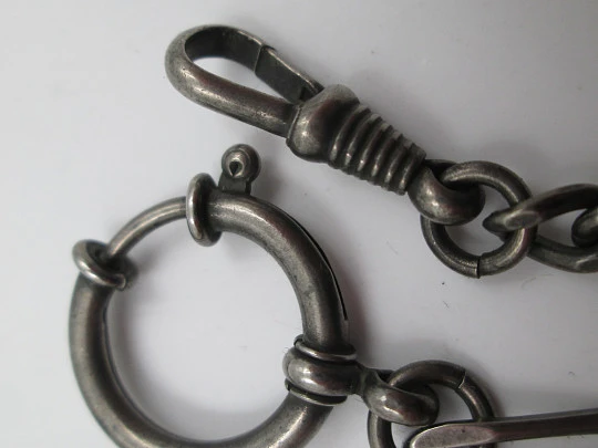 Cadena para reloj bolsillo. Metal pavonado. Eslabones abiertos. Mosquetón y argolla. 1940