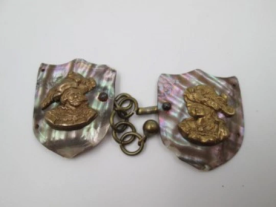 Cape clasp. Brass and mother-of-pearl. 1910-20. Man and woman