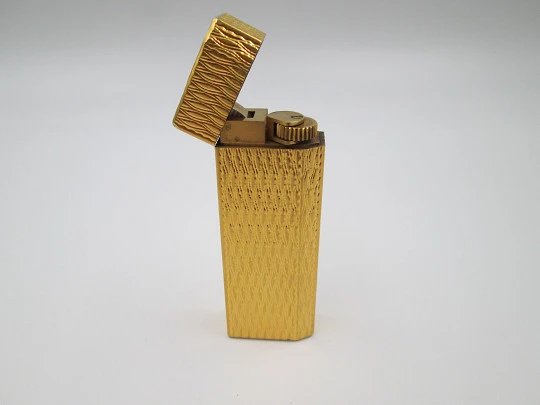 Cartier butane pocket lighter. Yellow rolled gold. Waves pattern. France. 1990's