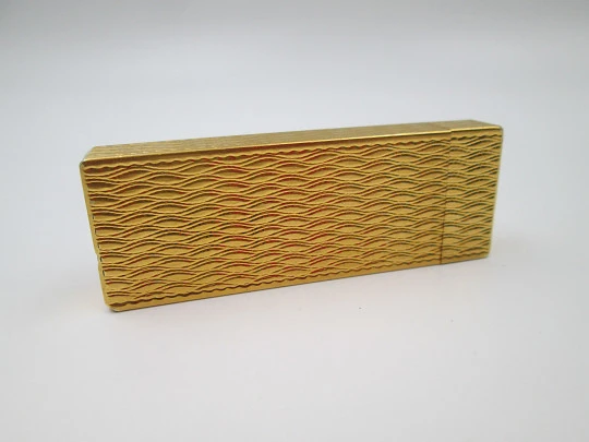 Cartier butane pocket lighter. Yellow rolled gold. Waves pattern. France. 1990's