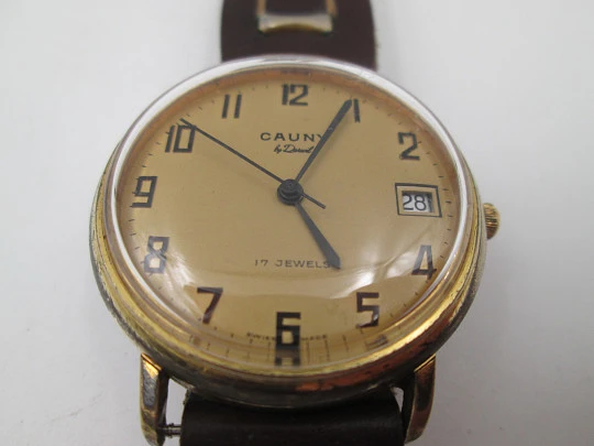 Cauny Darwil. Chapado en oro y acero inoxidable. Cuerda manual. Calendario. 1970