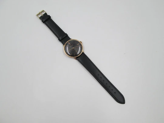 Cauny Prima De Luxe. 10 microns gold plated & steel. Manual wind. Black dial. 1970's. Swiss