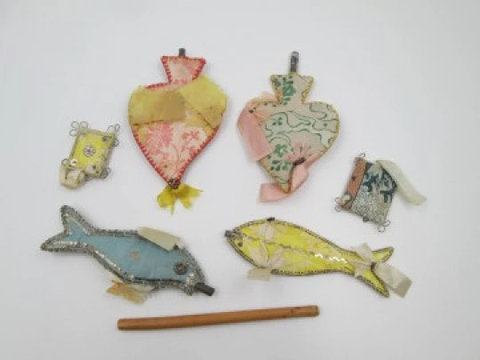 Colección de seis exvotos de tela de colores y metal. Corazones y peces. 1950