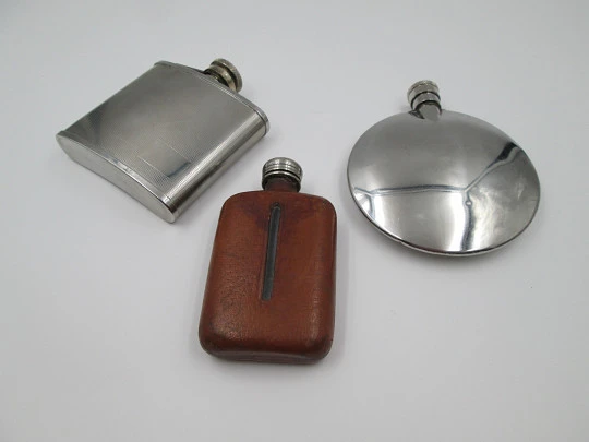 Collection three men's hip flasks. Stainless steel and leather. 1980's