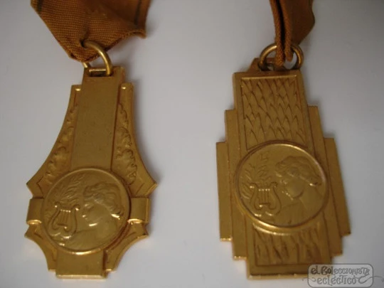 Couple medals. Golden metal. 1950's. Awards music. Women