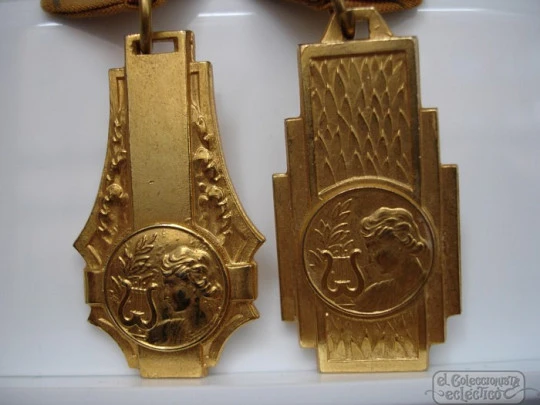 Couple medals. Golden metal. 1950's. Awards music. Women