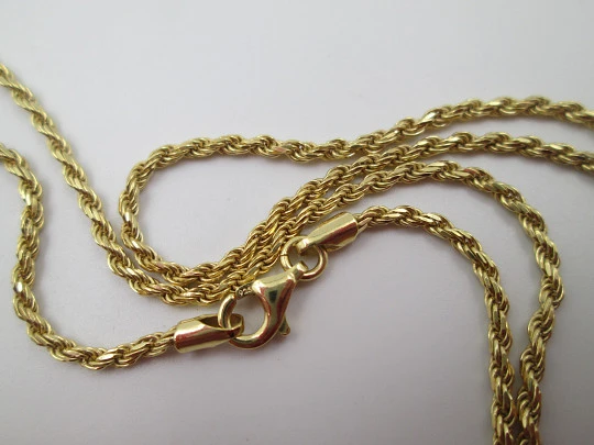 Crucifix pendant with braided cord. Golden sterling silver & white gems. 1980's. Europe