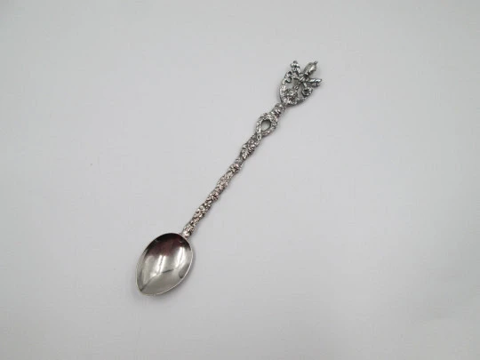 Cuchara larga ornamental. Metal plateado. Escudo pontificio, querubín y motivos florales Cuchara larga ornamental. Metal plateado. Escudo pontificio, querubín y motivos florales