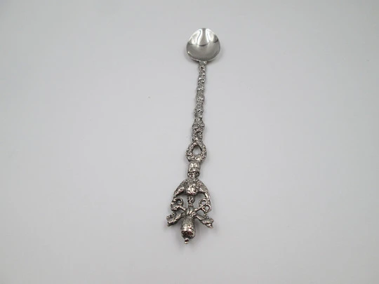Cuchara larga ornamental. Metal plateado. Escudo pontificio, querubín y motivos florales