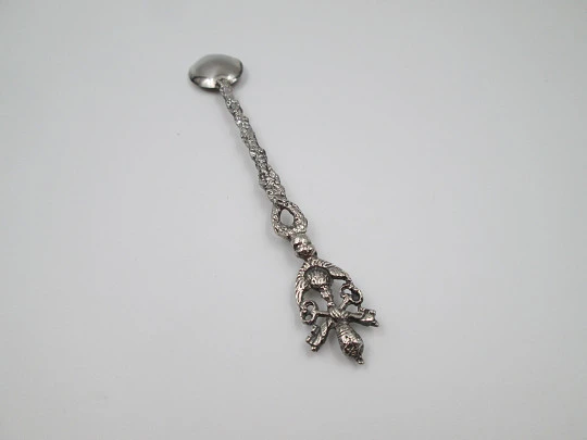 Cuchara larga ornamental. Metal plateado. Escudo pontificio, querubín y motivos florales