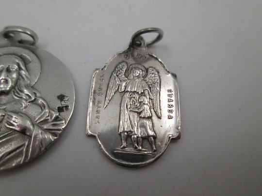 Dos medallas religiosas en plata de ley. Virgen de Montserrat y Ángel de la Guarda. 1960 Dos medallas religiosas en plata de ley. Virgen de Montserrat y Ángel de la Guarda. 1960