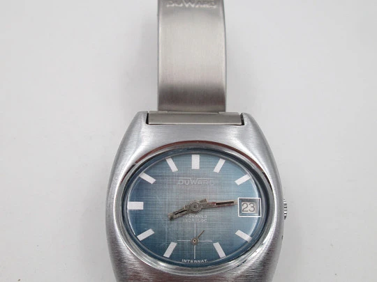 Duward Internat reloj unisex. Metal niquelado y acero. Dial azul. Calendario. Brazalete. 1970