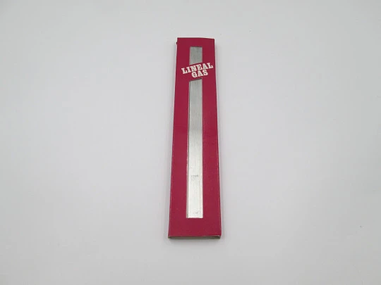 Encendedor de bolsillo a gas. Regla graduada. Metal plateado. Estuche original. 1980