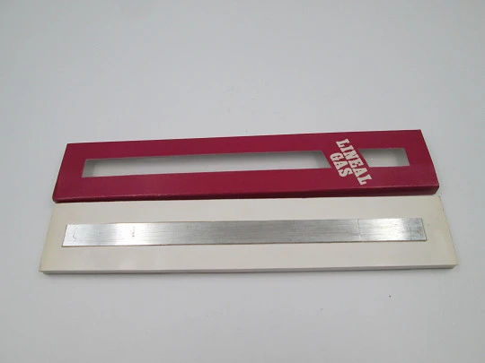 Encendedor de bolsillo a gas. Regla graduada. Metal plateado. Estuche original. 1980