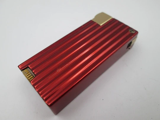 Encendedor de bolsillo a gasolina Benlow Golmet. Aluminio rojo y dorado. 1950