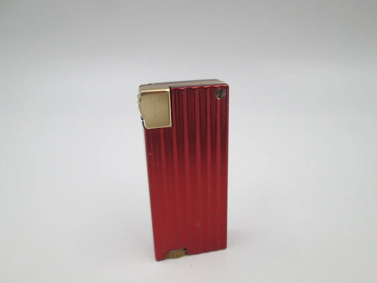 Encendedor de bolsillo a gasolina Benlow Golmet. Aluminio rojo y dorado. 1950