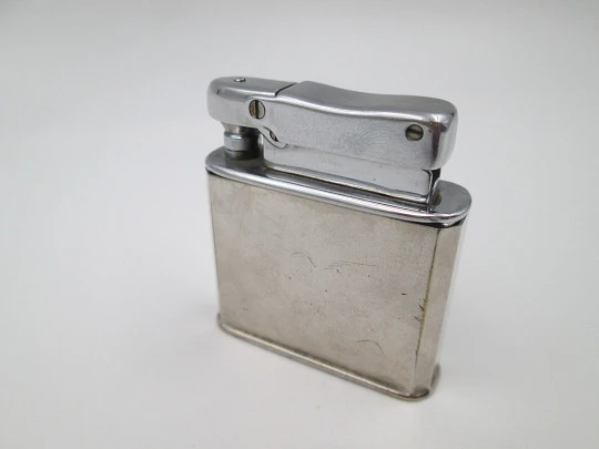 Encendedor de bolsillo a gasolina Ibelo Monopol. Metal plateado. Motivo flautista. 1950