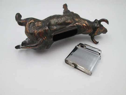 Encendedor de despacho a gasolina. Toro bravo. Bronce y metal plateado. Europa. 1970
