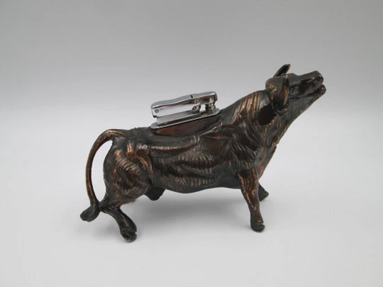 Encendedor de despacho a gasolina. Toro bravo. Bronce y metal plateado. Europa. 1970