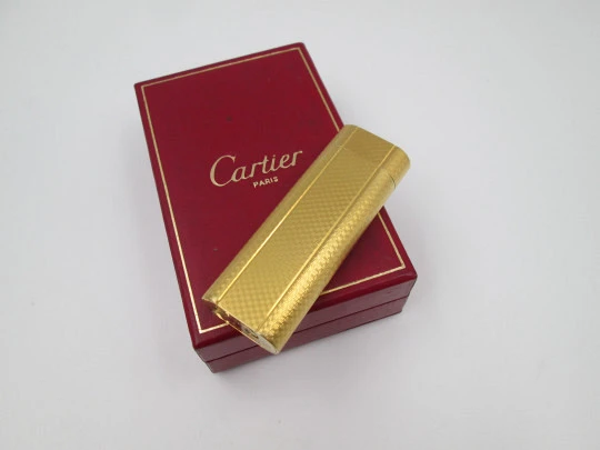 Encendedor de gas Cartier. Laminado en oro amarillo. Patrón de ondas. Estuche. 1990