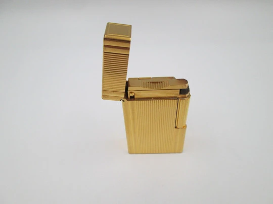 Encendedor de gas S.T. Dupont París. Chapado en oro. Patrón lineal. Estuche. 1990. Francia Encendedor de gas S.T. Dupont París. Chapado en oro. Patrón lineal. Estuche. 1990. Francia