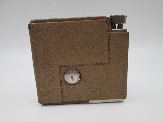 Encendedor de mecha a gasolina con pitillera. Metal plateado y piel marrón. Austria. 1950