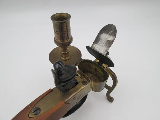 Encendedor de yesca con forma de pistola y portavela. Hierro, latón y madera. Italia, 1960 Encendedor de yesca con forma de pistola y portavela. Hierro, latón y madera. Italia, 1960