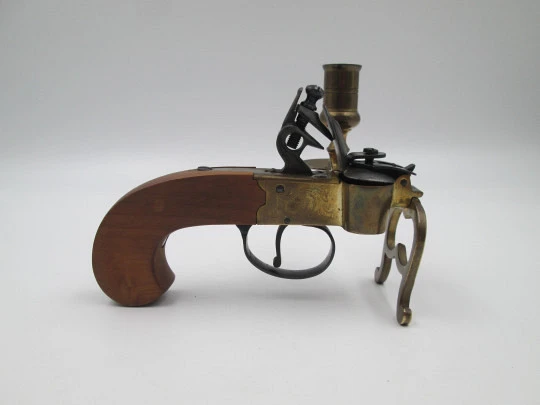 Encendedor de yesca con forma de pistola y portavela. Hierro, latón y madera. Italia, 1960 Encendedor de yesca con forma de pistola y portavela. Hierro, latón y madera. Italia, 1960