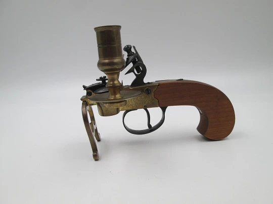Encendedor de yesca con forma de pistola y portavela. Hierro, latón y madera. Italia, 1960 Encendedor de yesca con forma de pistola y portavela. Hierro, latón y madera. Italia, 1960