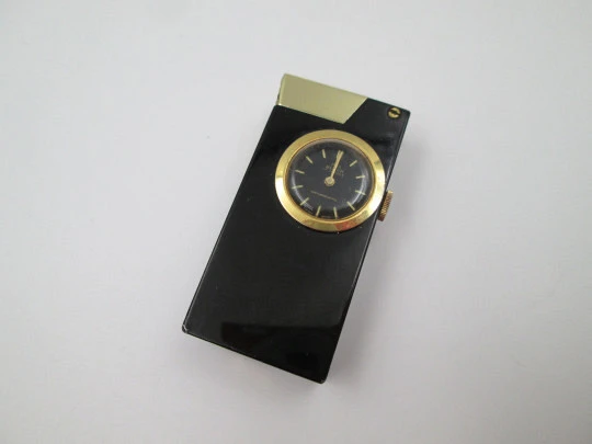 Encendedor gasolina / reloj mecánico Buler. Metal lacado negro y chapado oro. Suiza. 1960