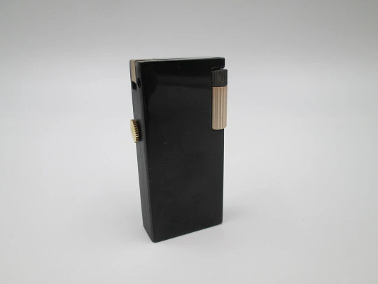 Encendedor gasolina / reloj mecánico Rivo. Metal lacado negro y chapado oro. Suiza. 1960