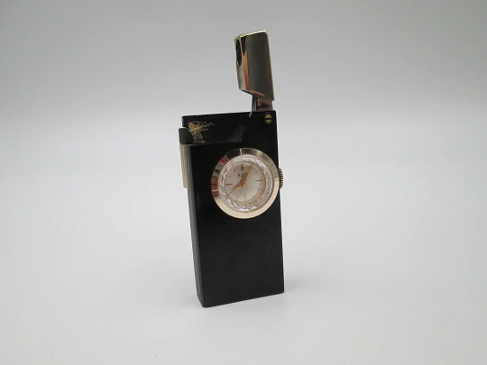 Encendedor gasolina / reloj mecánico Rivo. Metal lacado negro y chapado oro. Suiza. 1960