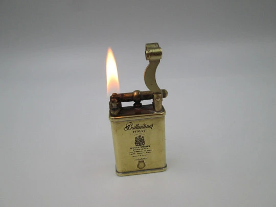 Encendedor publicitario de bolsillo a gasolina Ballantine's. Modelo de martillo. Metal dorado
