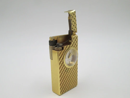 Encendedor reloj mecánico Foska. Metal chapado oro. Patrón romboidal. Suiza. 1960 Encendedor reloj mecánico Foska. Metal chapado oro. Patrón romboidal. Suiza. 1960