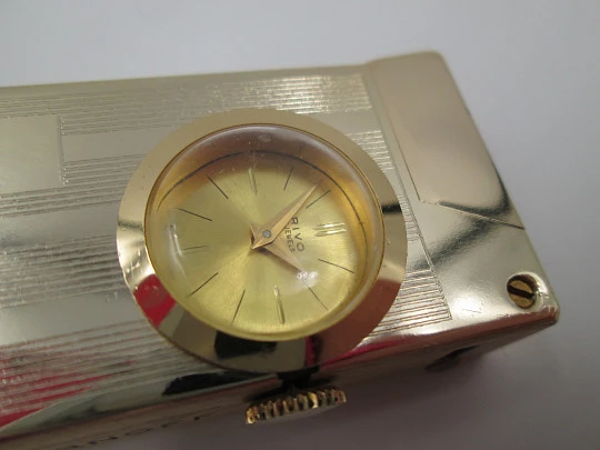 Encendedor reloj mecánico Rivo. Metal chapado oro. Base extraíble. 1960. Suiza
