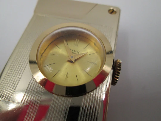 Encendedor reloj mecánico Rivo. Metal chapado oro. Base extraíble. 1960. Suiza