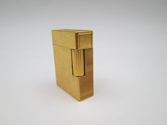 Encendedor S.T. Dupont. Chapado en oro. Patrón lineal y anagrama. 2001
