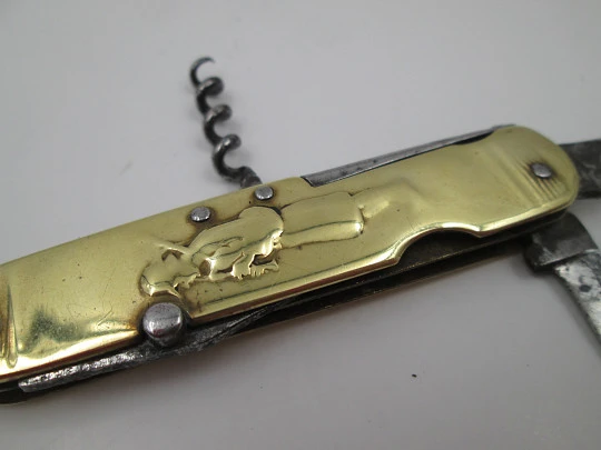 Figurative pocket knife. Brass and steel. Embossed bagpiper and woman. 1930's