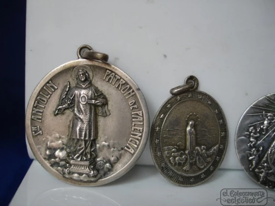 Four medals. Sterling silver. Virgin and Saints. Relief. 1920's